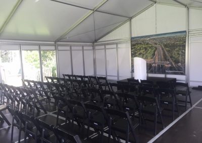 Road Opening - VIP marquee with black folding chairs and stage